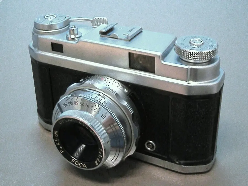 Appareil photo Focasport chromé et noir vu de trois quarts, objectif gravé Foca