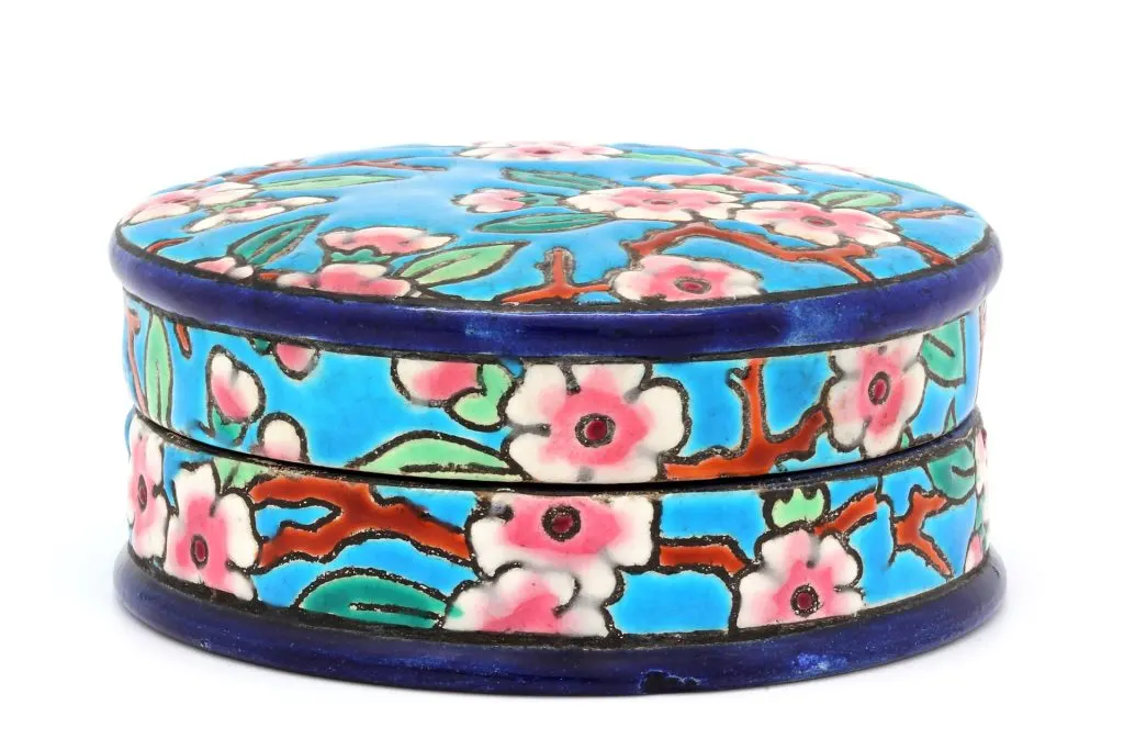 Boîte ronde en émail de Longwy à décor de fleurs roses sur fond bleu turquoise, bordures bleu foncé