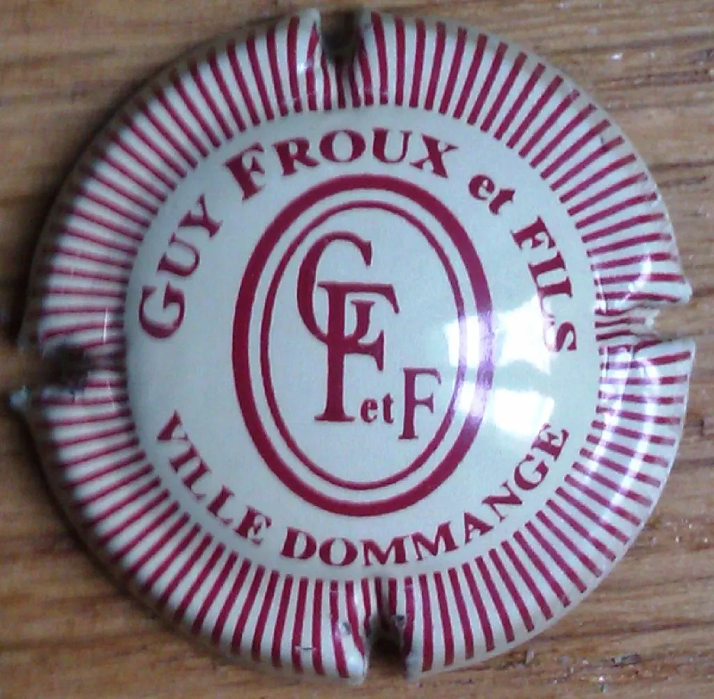 Capsule blanche à rayons bordeaux marquée Guy Froux et Fils, Ville Dommange, avec le monogramme GF et F