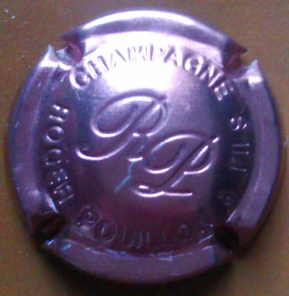 Capsule rose métallisée Champagne Roger Pouillon avec monogramme RP en relief au centre