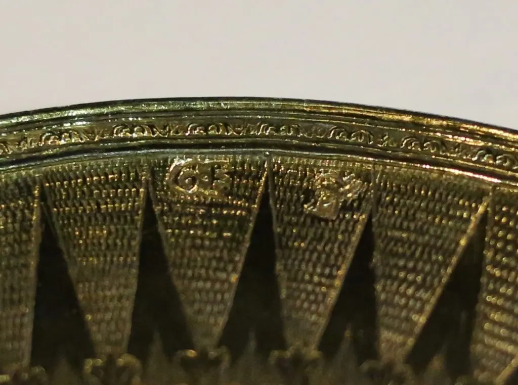 Deux petits poinçons frappés sur le rebord doré et ciselé d'une patène ancienne
