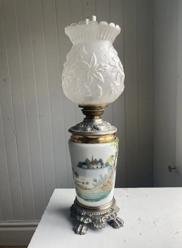 Lampe à pétrole à réservoir blanc peint d'un paysage, monture métallique et tulipe en verre dépoli moulé
