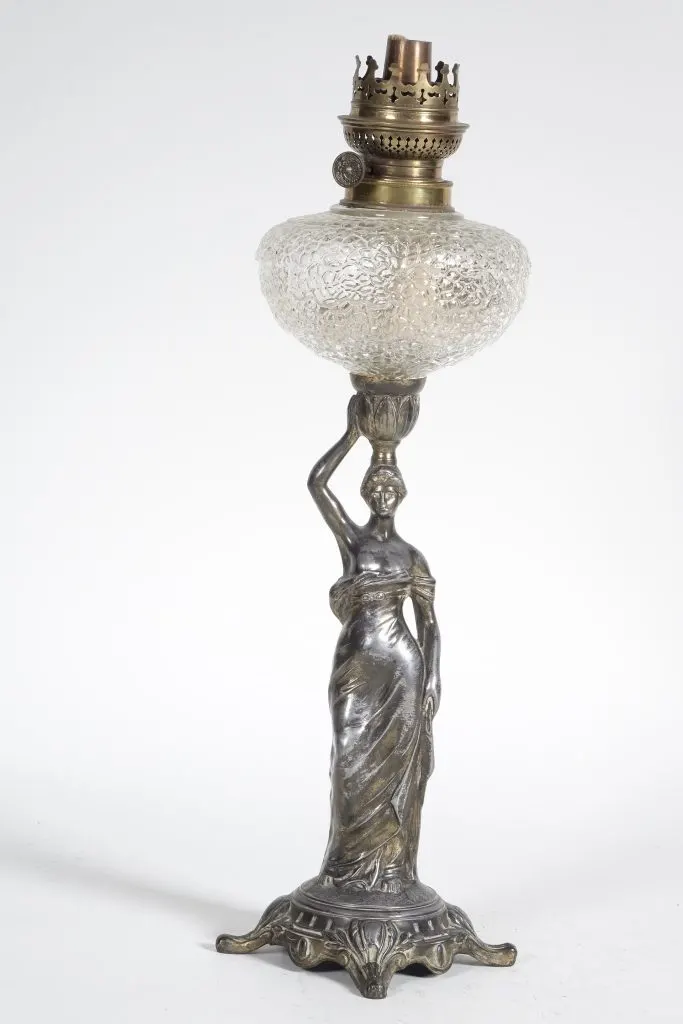 Lampe de table en régule bronzé figurant une femme qui porte sur la tête un réservoir en verre