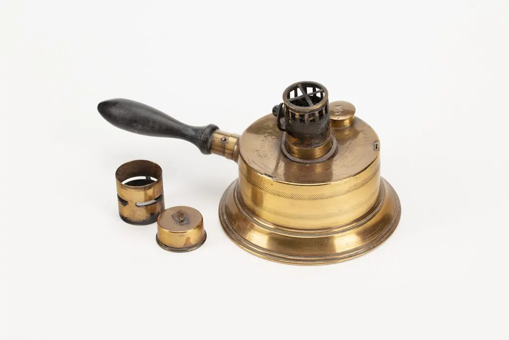 Lampe portative en laiton à manche en bois avec son bec ajouré et deux capuchons posés à côté
