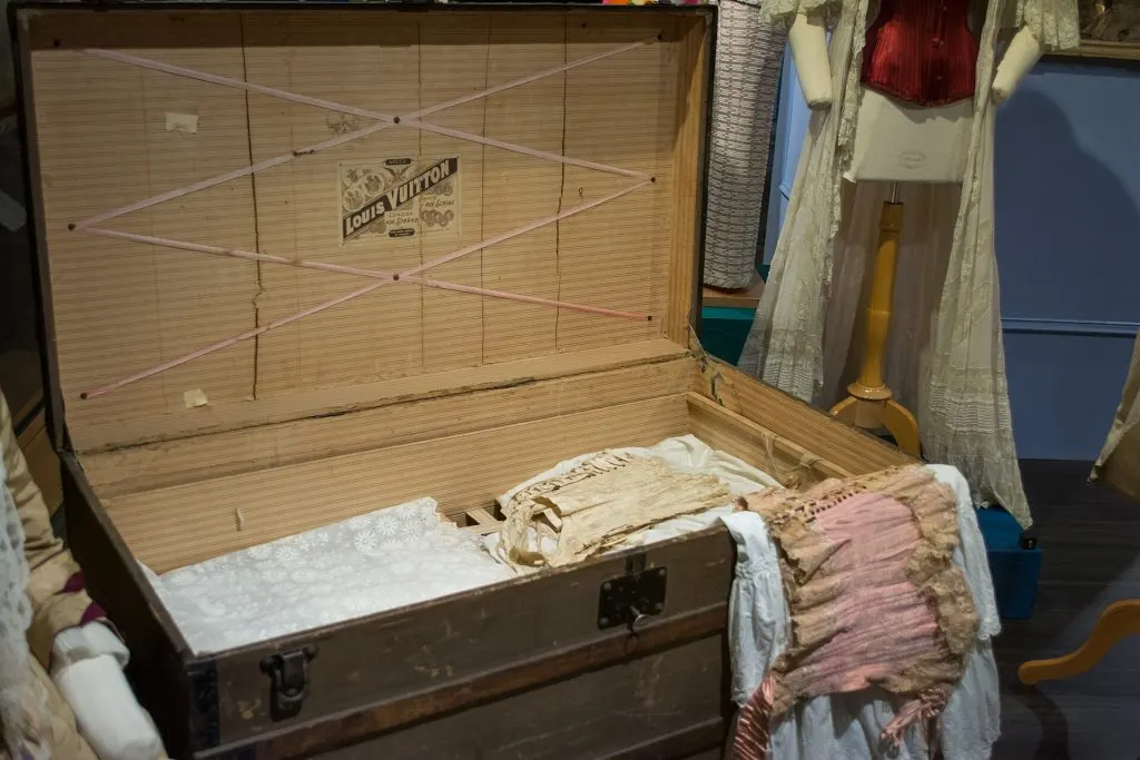 Malle Louis Vuitton ouverte avec l'étiquette de la maison collée au centre du couvercle et un trousseau à l'intérieur