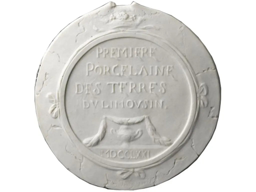 Médaillon en porcelaine blanche portant l'inscription Première porcelaine des terres du Limousin et la date MDCCLXXI