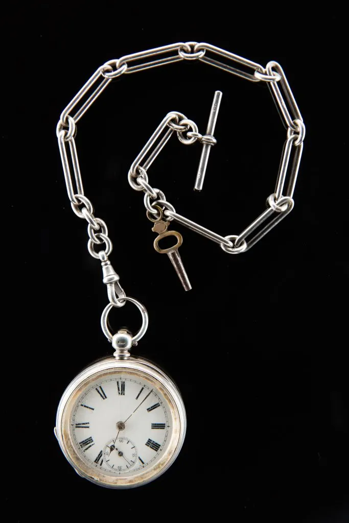 Montre de poche en argent à cadran émaillé, avec sa longue chaîne à maillons et sa clé de remontage en laiton