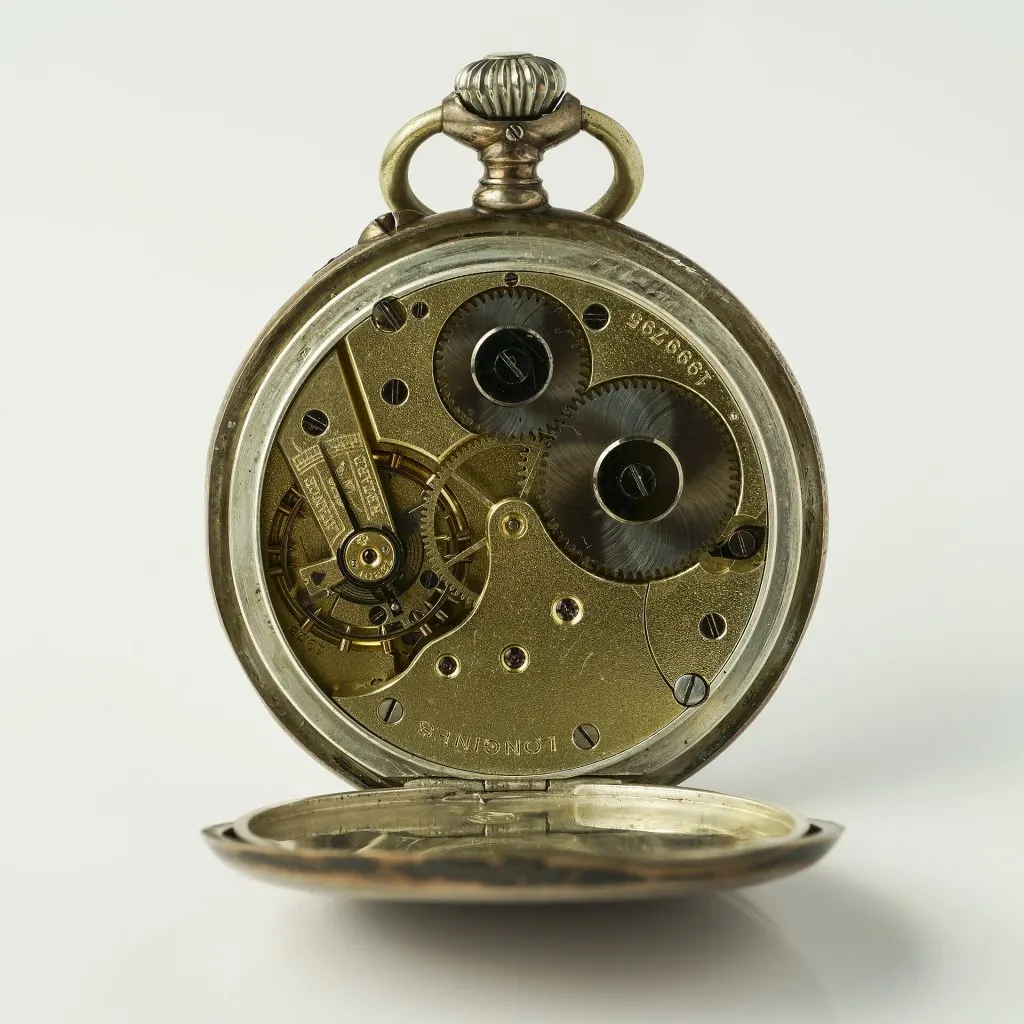 Montre de poche Longines en argent vue de dos, fond ouvert sur le mouvement mécanique doré et ses rouages