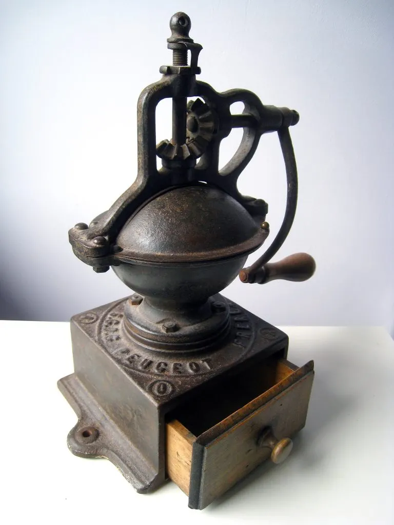 Moulin à café de comptoir en fonte noire, roue latérale et inscription Peugeot Frères moulée sur le socle