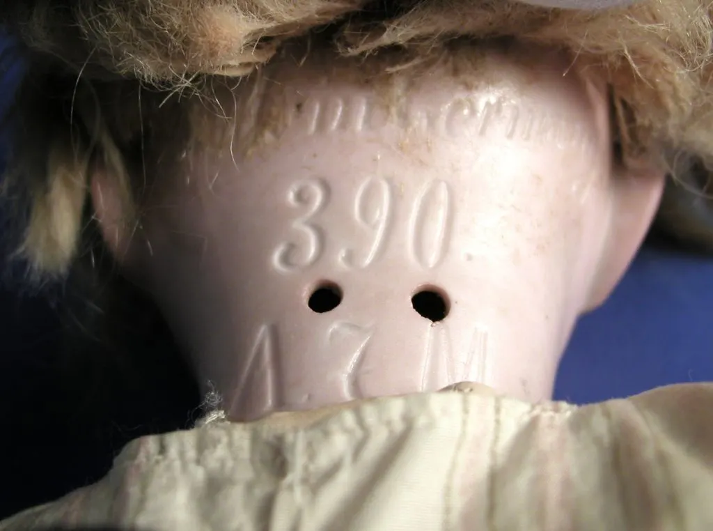 Nuque d'une tête de poupée en biscuit gravée 390 et A.M. sous la perruque