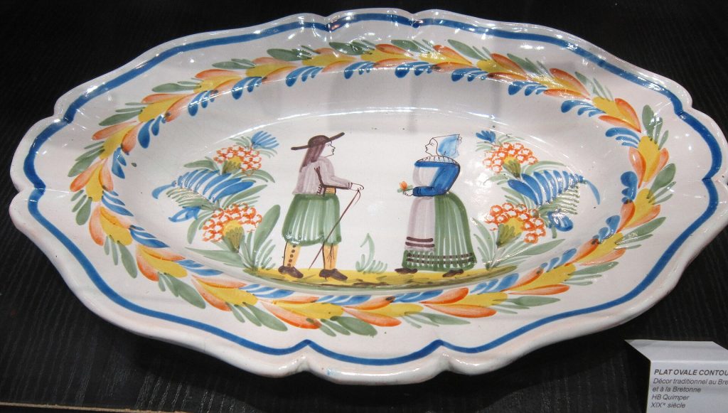 Plat ovale en faïence de Quimper décoré d'un couple de Bretons en costume