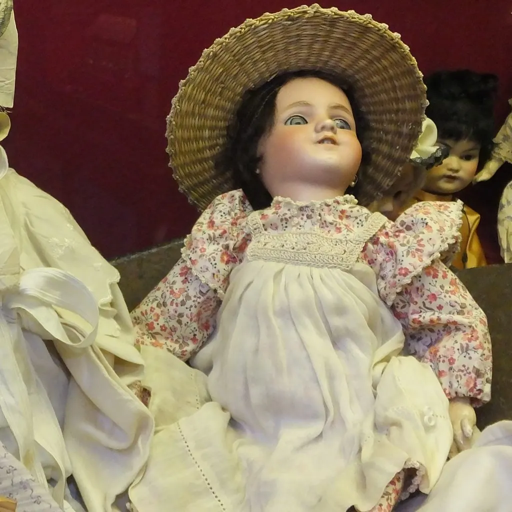 Poupée Simon & Halbig à tête en biscuit, yeux bleus, chapeau de paille et robe fleurie à tablier blanc