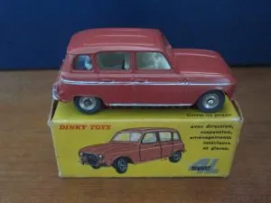 Renault 4L miniature Dinky Toys rouge posée sur sa boîte jaune d'origine illustrée