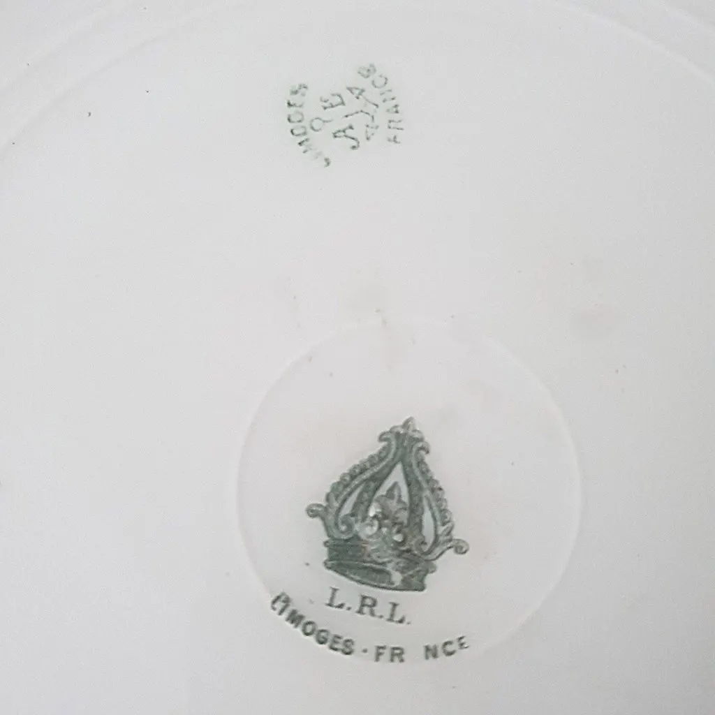 Revers d'une assiette avec une petite marque verte et la marque L.R.L. Limoges France sous un emblème