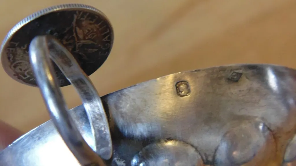 Tastevin en argent dont l'appui-pouce est formé d'une pièce de monnaie, poinçon visible sur le flanc